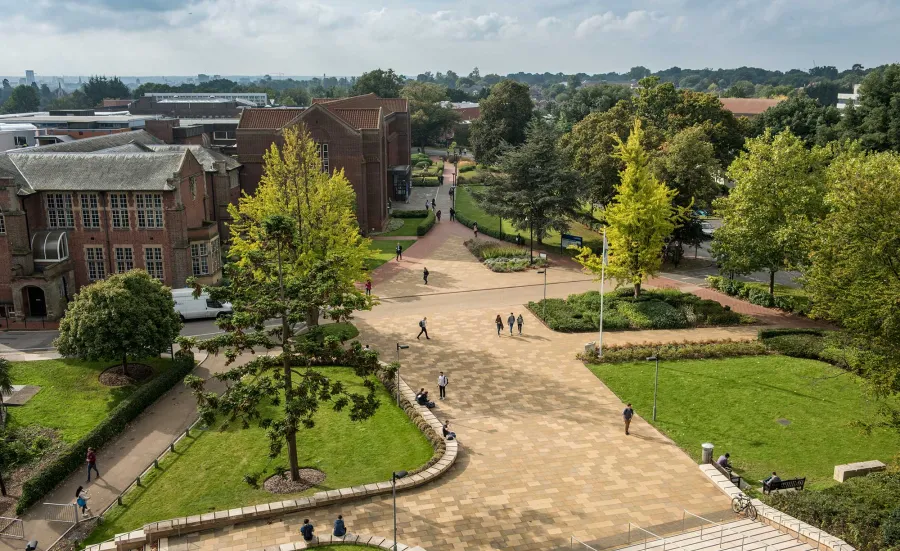 Aerial view of campus buildings, trees and courtyard area on a sunny day.