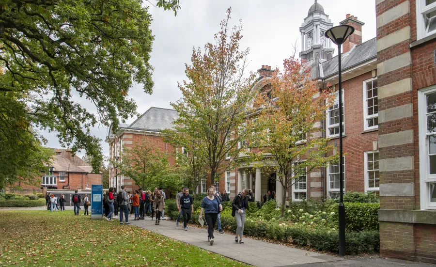 Students outside main building of Avenue Campus on spring day.