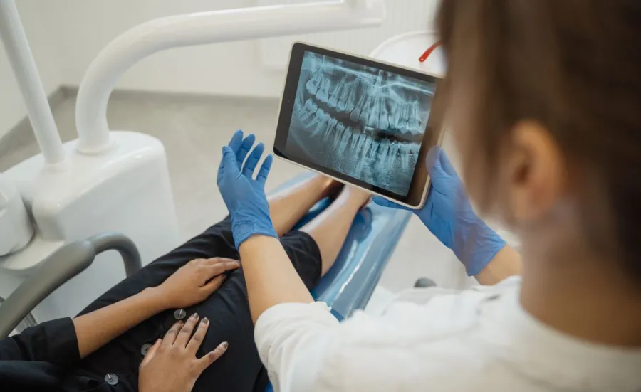 Dental professional and client in a consultation looking at an xray