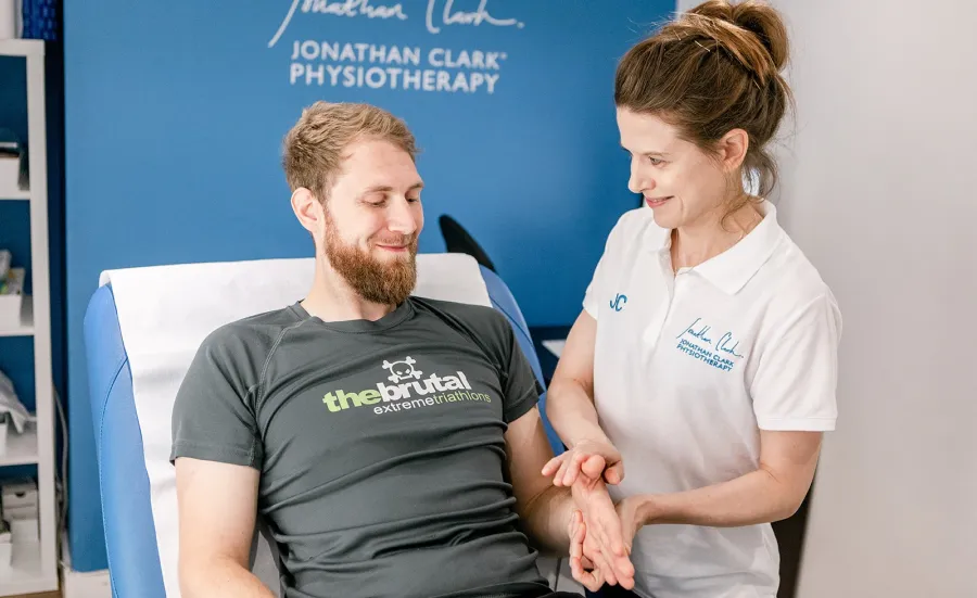 A physiotherapist examining a clients arm