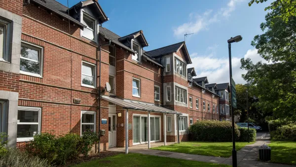 Exterior view of red brick, two storey accommodation building on a sunny day.