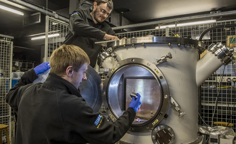 Two students operating a salt-fog chamber.