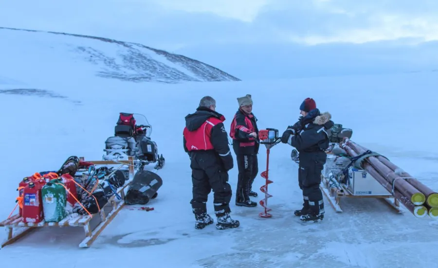 A team of scientists with equipment carrying out field research on a glacier