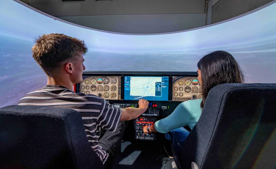 Two students at the controls of the flight simulator