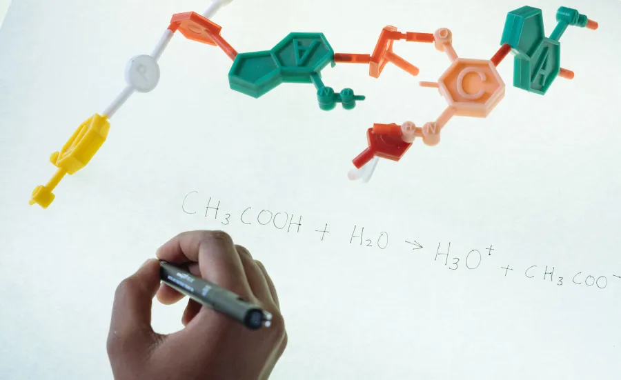 Chemical equation written on a whiteboard with red, green and orange pen