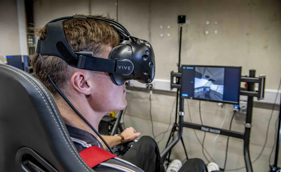 A student wears virtual reality goggles in the flight simulator