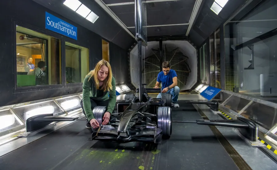 Two students work conduct a race car experiment in the R J Mitchell wind tunnel
