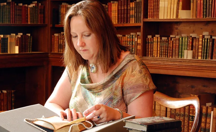 A postgraduate researcher studying a text at Chawton House library.