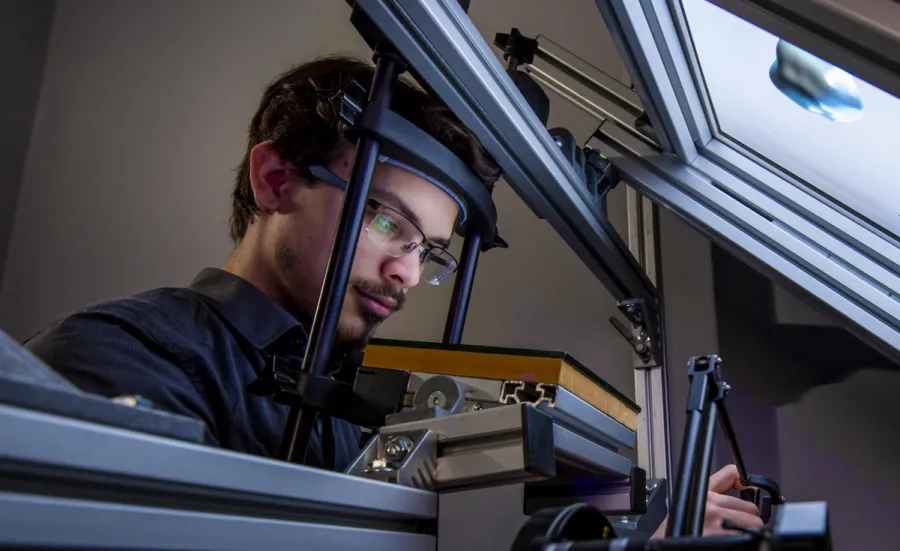 A research student uses equipment in the visual haptic lab