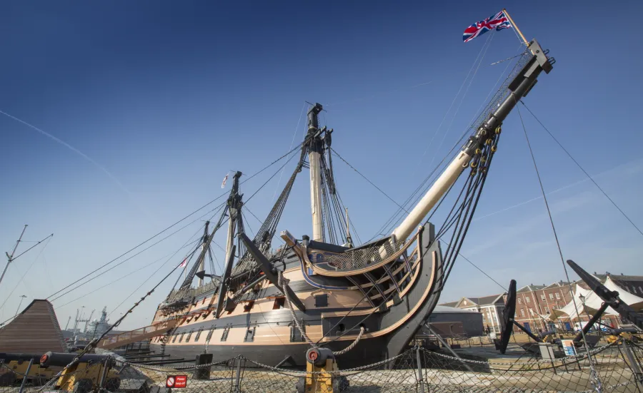 An exterior view of HMS Victory docked at Portsmouth Historic Dockyard.