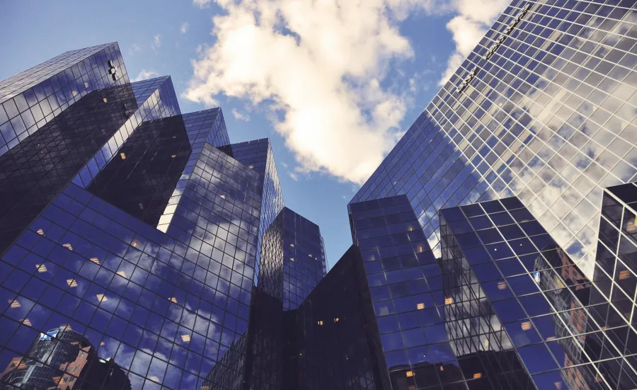 Low-angle view of city office buildings reflecting the sky