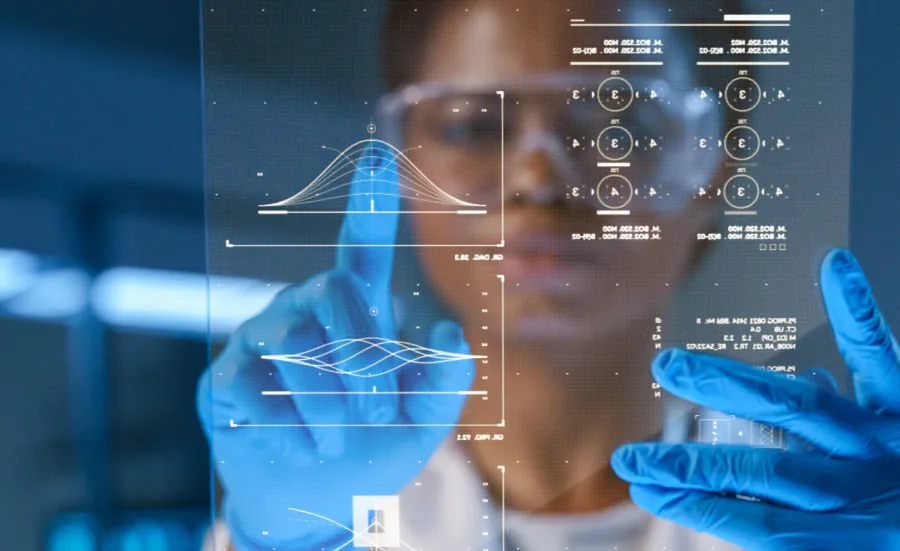 A researcher wearing blue medical gloves scrolls data on a screen