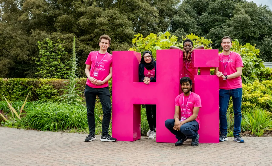 Students standing in front of Hi sign