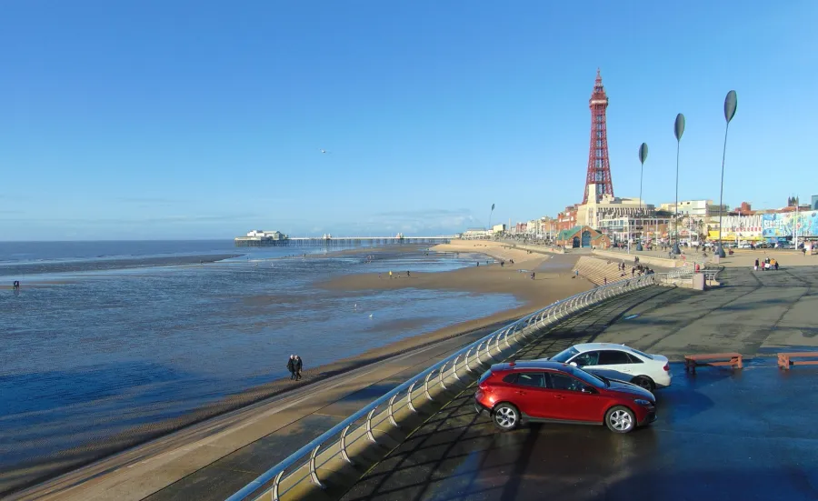 View of Blackpool Tower, beach and coastal defences on a sunny day.