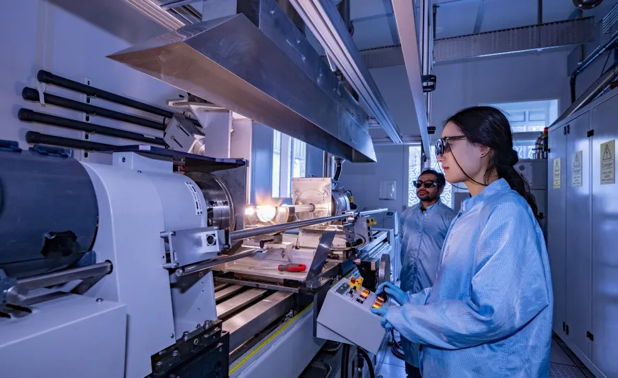 A man and a woman doing preform fabrication on MCVD lathe