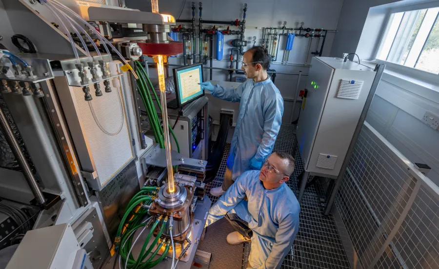 Two men building microstructured fibre preform in furnace