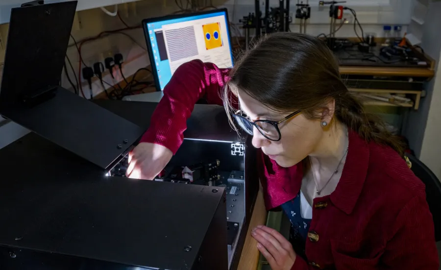 A woman checking fibre refractive index profiling