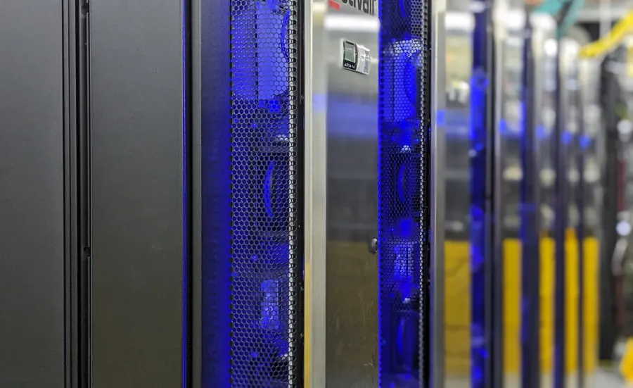 The IRIDIS 6 research computing facility. A series of servers in silver casing with blue and yellow network cables in the background.