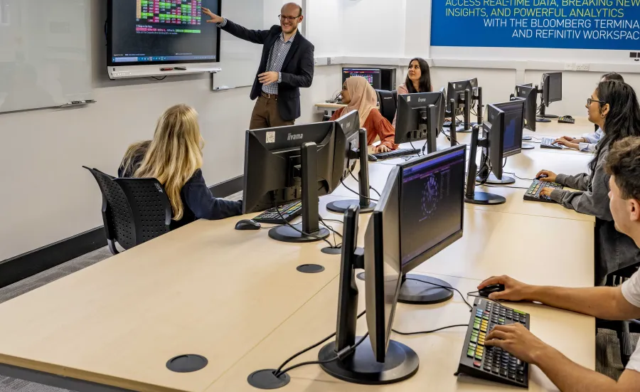 Students in the financial lab watching the lecturer present.