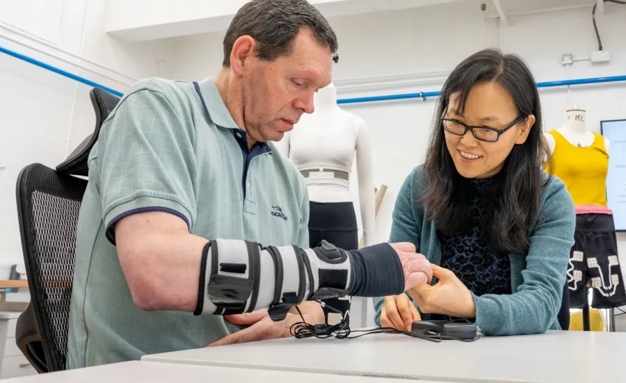 A patient wearing a forearm support receives therapy on his hand