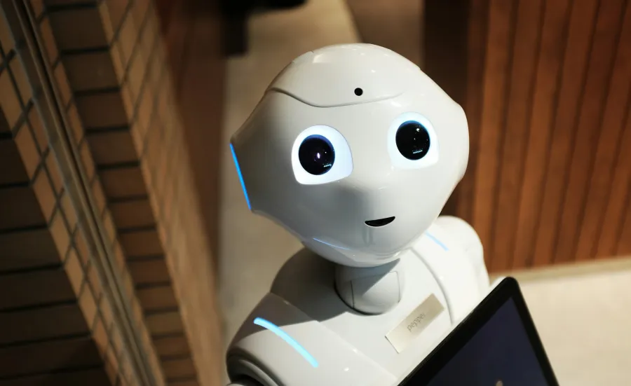 Head and shoulders of a robot with large eyes looking at the camera