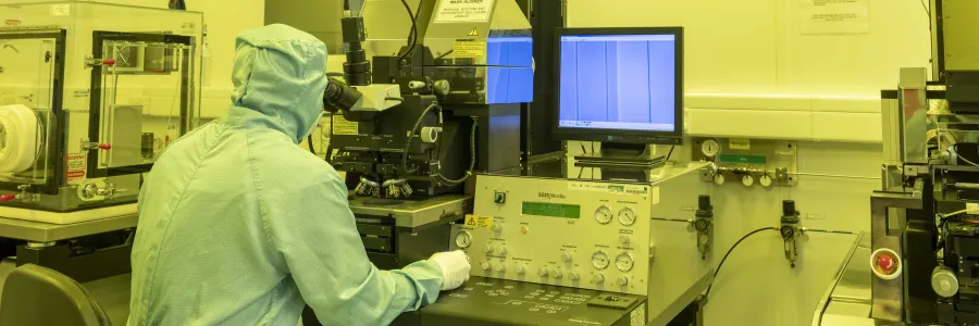 Integrated Photonics Cleanroom - a researcher in a cleanroom suit uses the Karl Zuss MA6 contact aligner