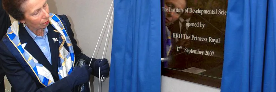 Princess Anne unveiling a commemorative plaque by pulling back a royal blue curtain. The plaque signifies the opening of the Institute of Developmental Sciences on the 17th of September 2007.