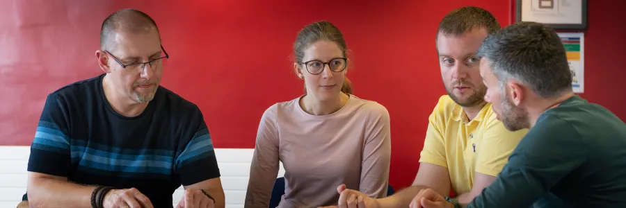 People in a meeting discussion around a table.