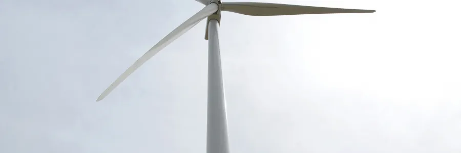 Wind turbine under cloudy sky.