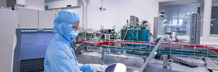 A researcher wearing a cleanroom suit