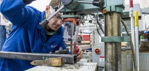 A student uses equipment in the engineering design and manufacturing centre