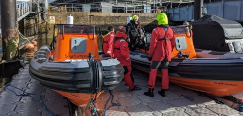 Course instructor and participants looking at 2 powerboats