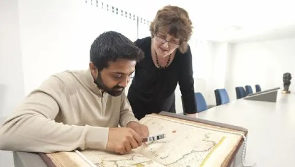 Staff looking at maps from the library archive