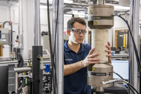 A student tests a concrete structure in the testing and structures research lab