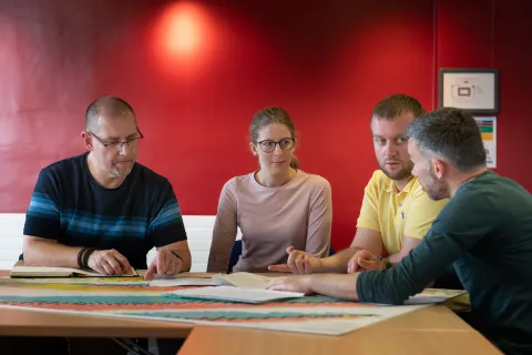 People in a meeting discussion around a table.