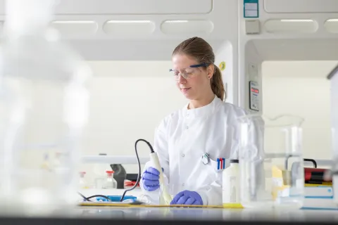 Scientist looking down and working with lab equipment