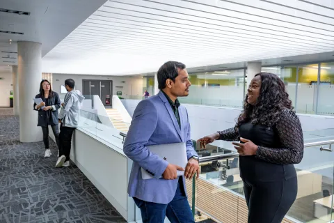 Students chatting on a balcony overlooking the MBA suite