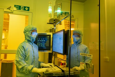 A woman standing near the computer in a laboratory