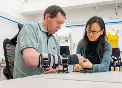 A patient wearing a forearm support receives therapy on his hand