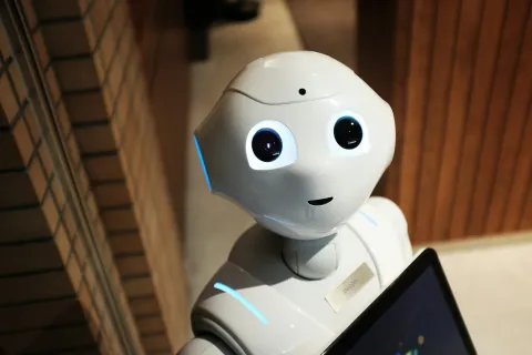 Head and shoulders of a robot with large eyes looking at the camera