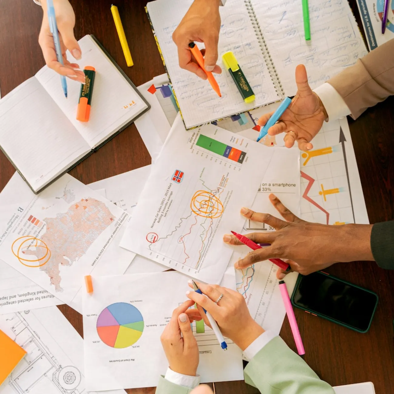 Colleagues pouring over statistical graphs in a work meeting.