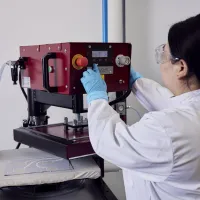 A woman researcher using a machine at the e-textile laboratory