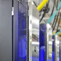 IRIDIS 6 research computing facility - a bank of servers in silver casing with yellow and blue network cables in the background