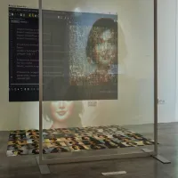 A multimedia installation at an exhibition, including photographs and projections of people.